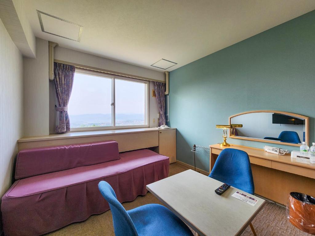 une chambre avec un lit, une table et des chaises dans l'établissement Iwanai Kogen Hotel, à Iwanai