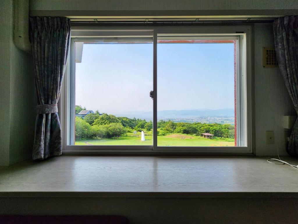 - une fenêtre dans une chambre avec vue sur la cour dans l'établissement Iwanai Kogen Hotel, à Iwanai