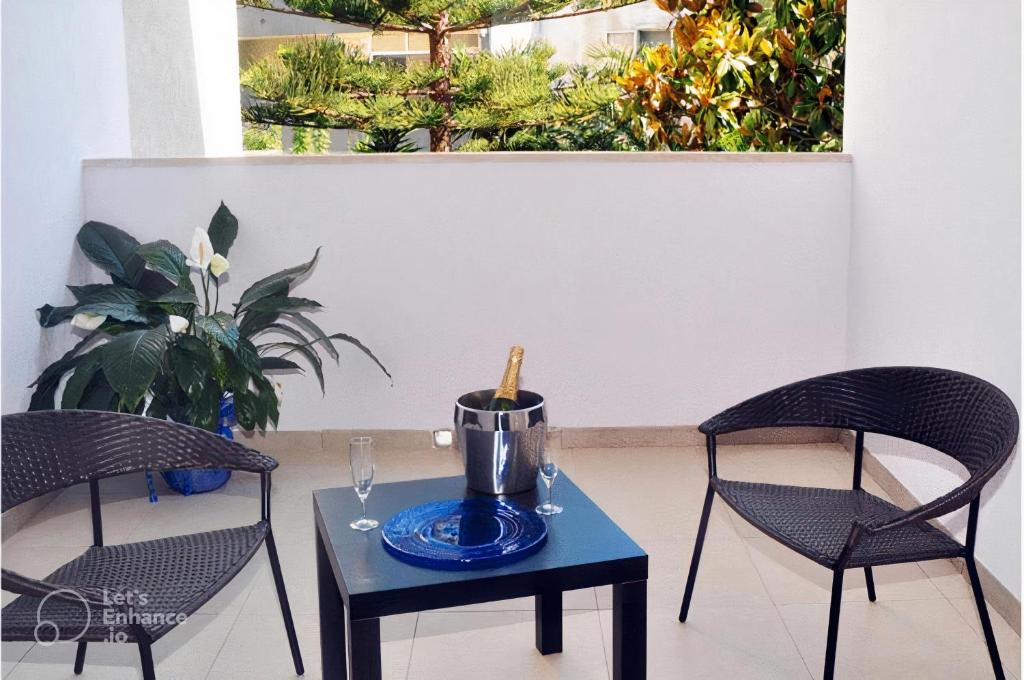 - deux chaises et une table avec une bouteille de vin dans l'établissement Hotel La Punta, à Otrante