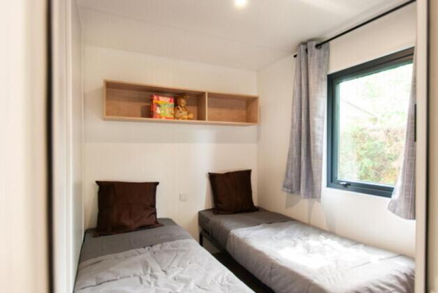 une chambre avec deux lits et une fenêtre dans l'établissement Camping Lou Pignada, à Messanges