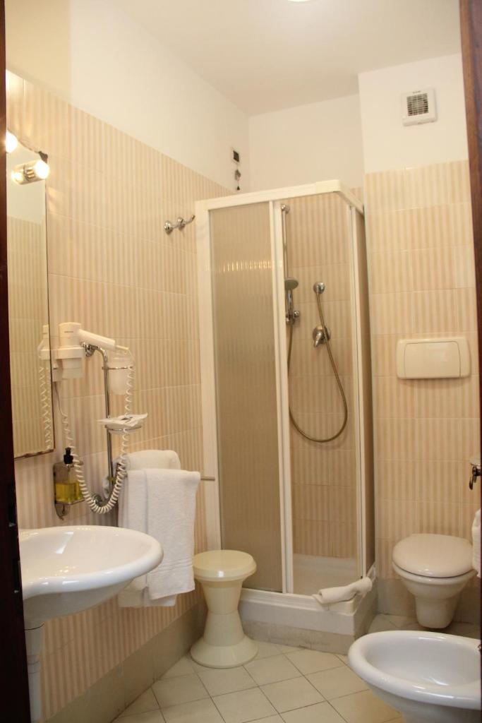une salle de bain avec une douche, des toilettes et un lavabo dans l'établissement Hotel Geranio Rosso, à Stintino