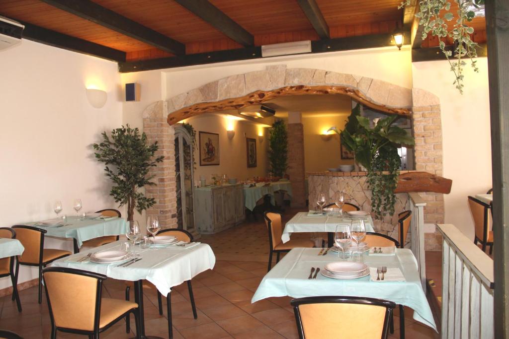 un restaurant avec des tables et des chaises dans une salle dans l'établissement Hotel Geranio Rosso, à Stintino