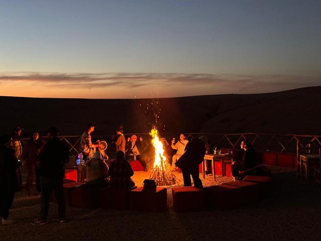 un groupe de personnes debout autour d'un feu dans l'établissement RIAD TENDANCE IN MARRAKECH, à Marrakech