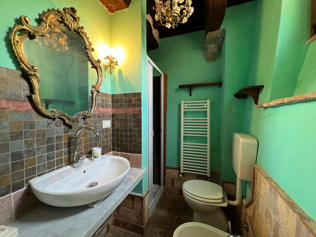 une salle de bain avec un lavabo, des toilettes et un miroir dans l'établissement Podere Beatrice 20 Pax by VILLASRETREATS, à Bardine di San Terenzo Monti