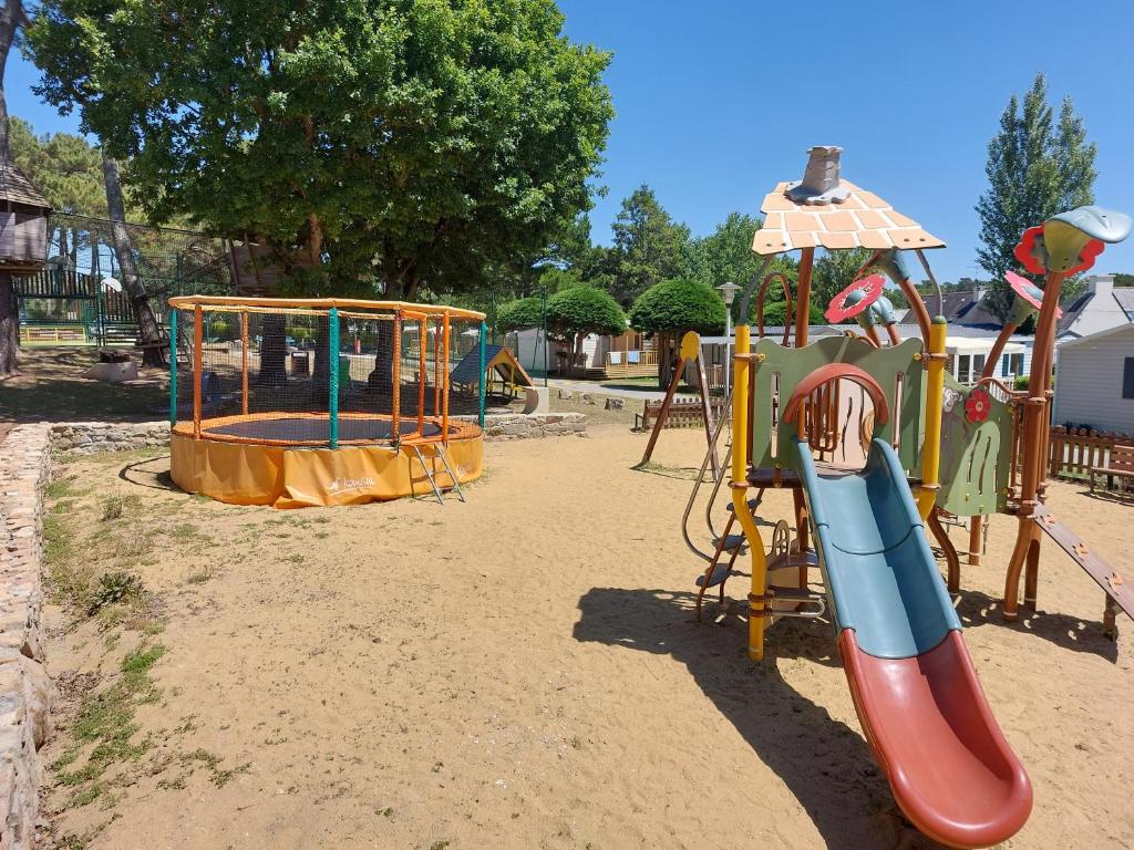 une aire de jeux avec un toboggan et une structure de jeu dans l'établissement CARNAC Mobil-Home Camping 4 étoiles, à Carnac