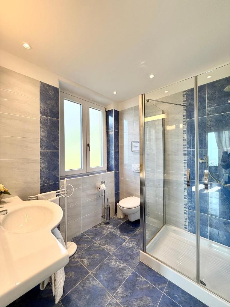 une salle de bain avec douche, lavabo et toilettes dans l'établissement Villa Charme, à Tremezzo