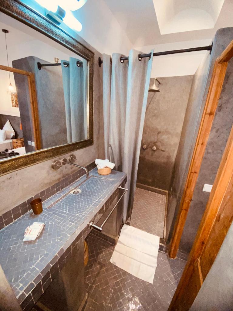une salle de bain avec un lavabo, un miroir et une douche dans l'établissement Riad Ambre et Jasmin, à Marrakech 37 autres photos