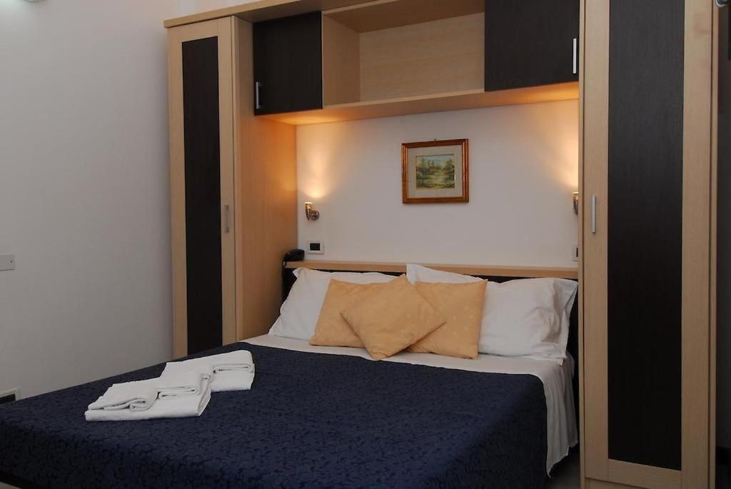 une chambre avec un lit avec deux serviettes dessus dans l'établissement Hotel Ambasciata, à Cesenatico