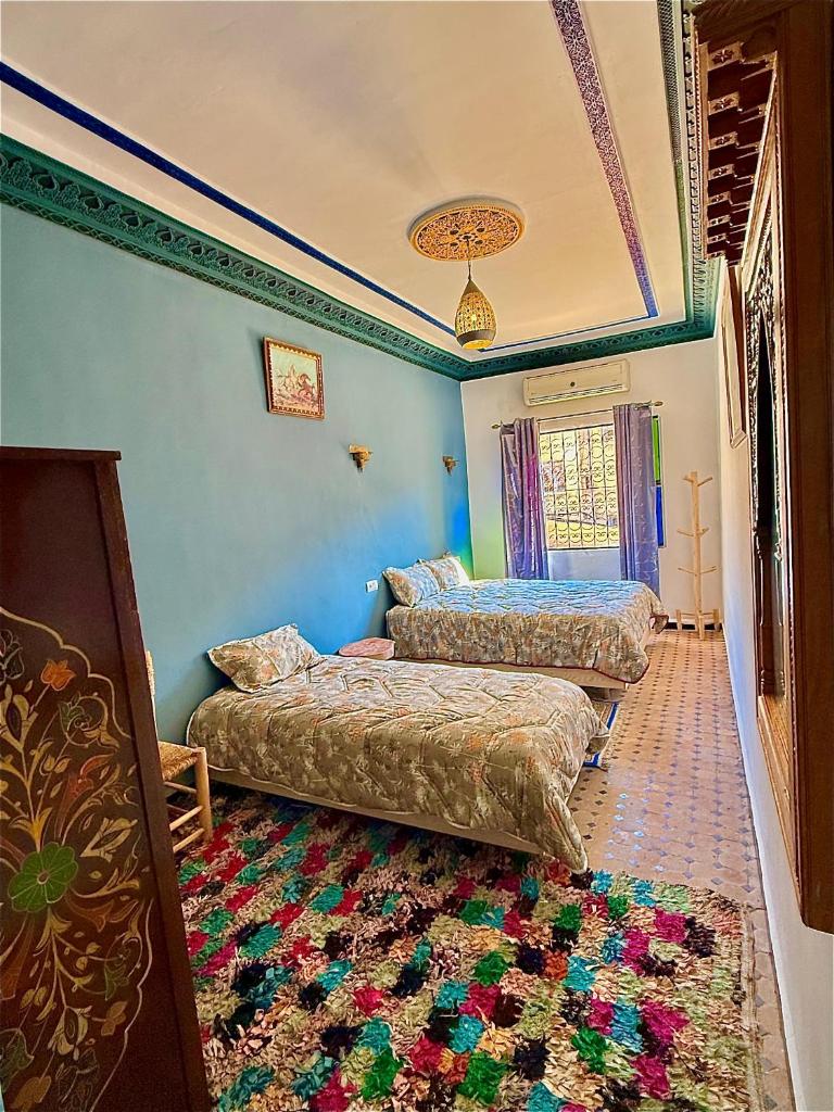 une chambre avec deux lits et un tapis dans l'établissement Riad DAR FES, à Fès