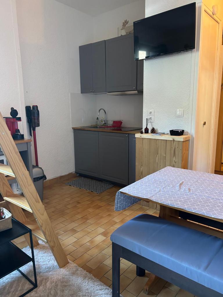 une cuisine avec une table et un comptoir dans l'établissement Le Lautaret, à La Salle Les Alpes