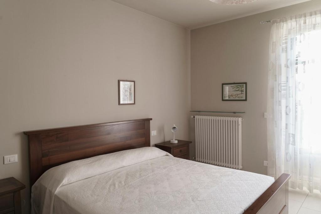 une chambre avec un grand lit et une fenêtre dans l'établissement Ca du Ji'uu, villa con piscina, à Castellinaldo 12 autres photos