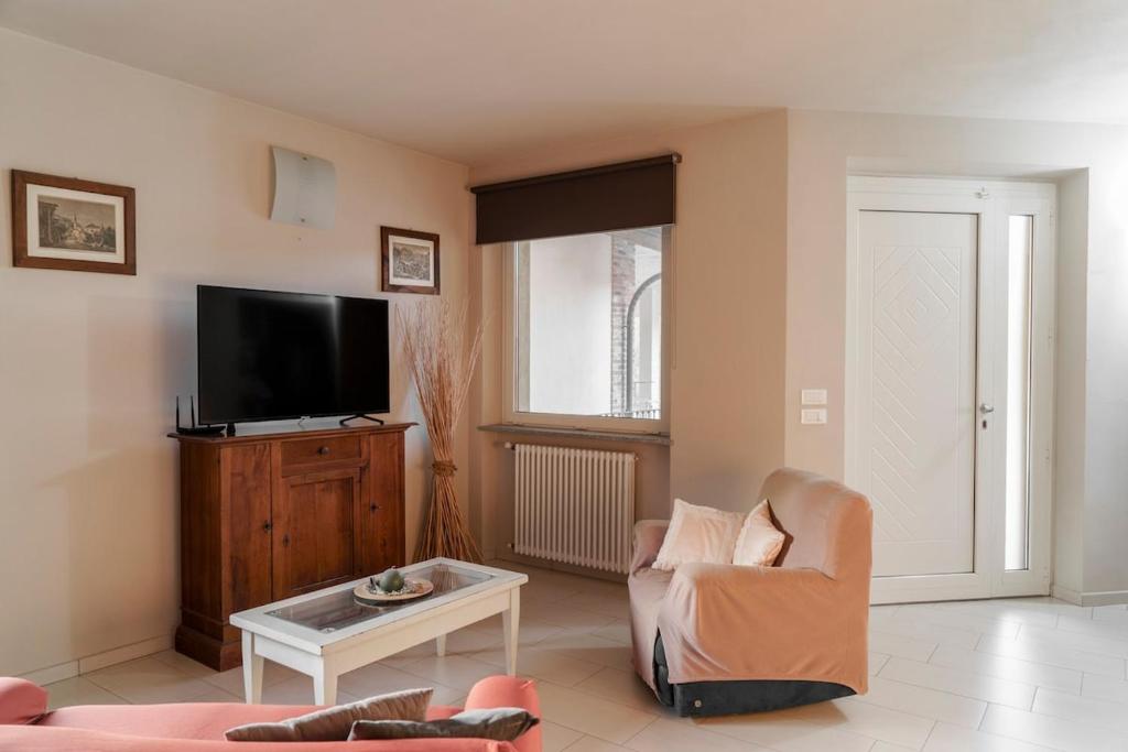 un salon avec une télévision, une chaise et une table dans l'établissement Ca du Ji'uu, villa con piscina, à Castellinaldo