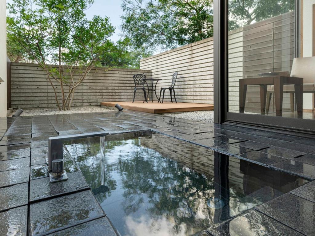 une terrasse avec une piscine, une table et des chaises dans l'établissement Kurhouse Shirahama, à Shirahama