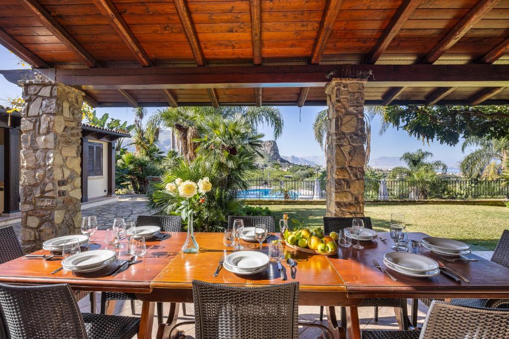 - une table en bois avec des verres à vin sur la terrasse dans l'établissement Villa Zagara Swimming Pool and Seaview, à Ficarazzi
