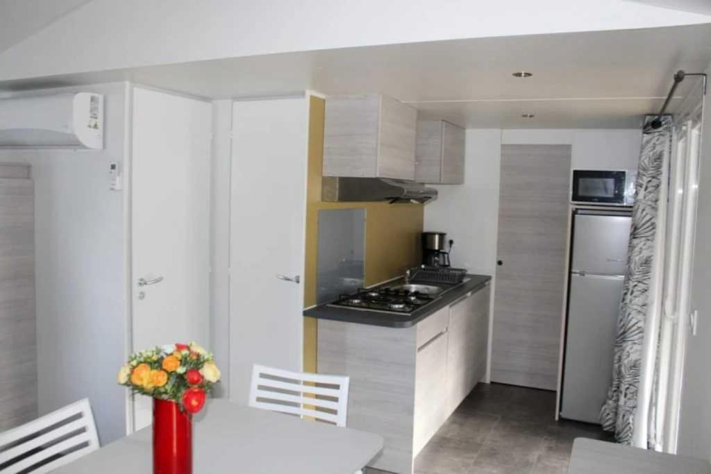 une cuisine avec une table et une cuisinière four supérieur dans l'établissement Camping 3 étoiles - Piscine - ccaffbe, à Bormes-les-Mimosas