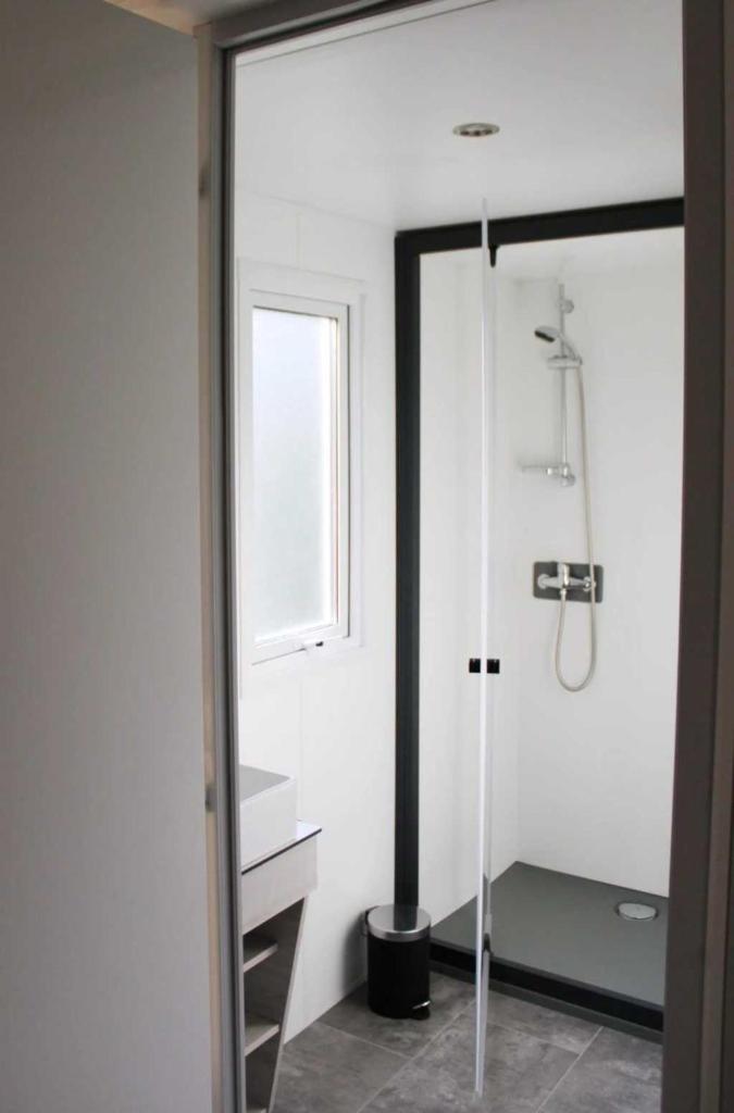 une salle de bain blanche avec une douche et un lavabo dans l'établissement Camping 3 étoiles - Piscine - ccaffbe, à Bormes-les-Mimosas
