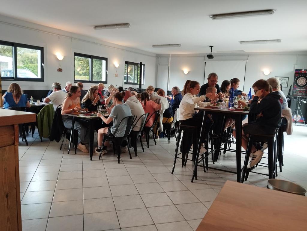 un groupe de personnes assises à des tables dans un restaurant dans l'établissement Camping Paradis L'Ile de Kernodet, à Saint-Molf 35 autres photos