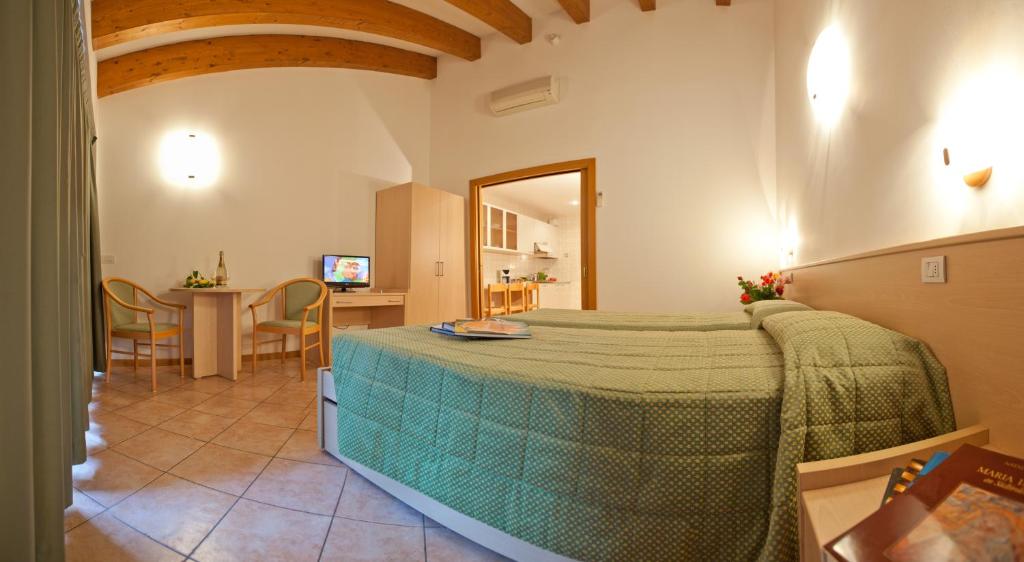 une chambre avec un lit et une table dans une pièce dans l'établissement Residence San Luigi, à Limone sul Garda