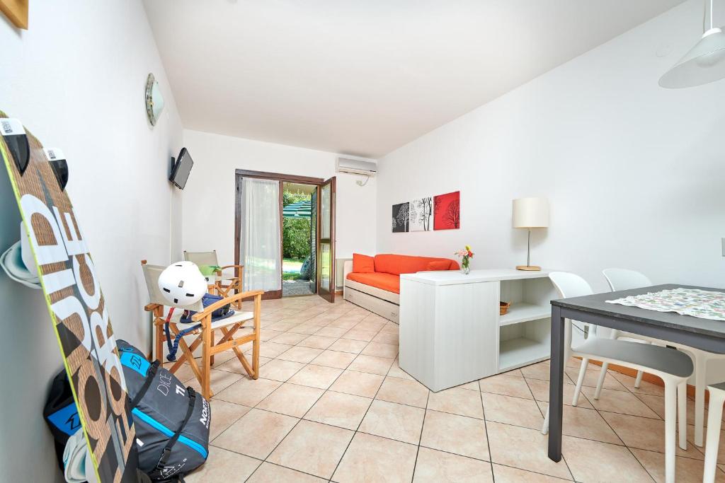 un salon avec un canapé rouge et une table dans l'établissement Residence San Luigi, à Limone sul Garda