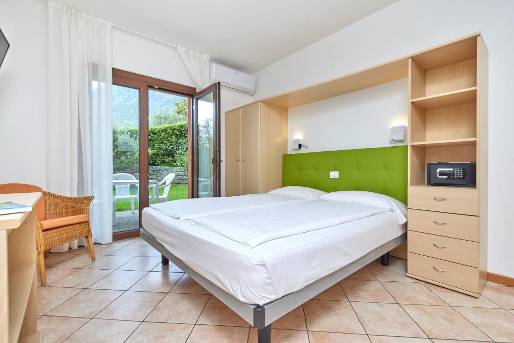 une chambre avec un grand lit et un bureau dans l'établissement Residence San Luigi, à Limone sul Garda