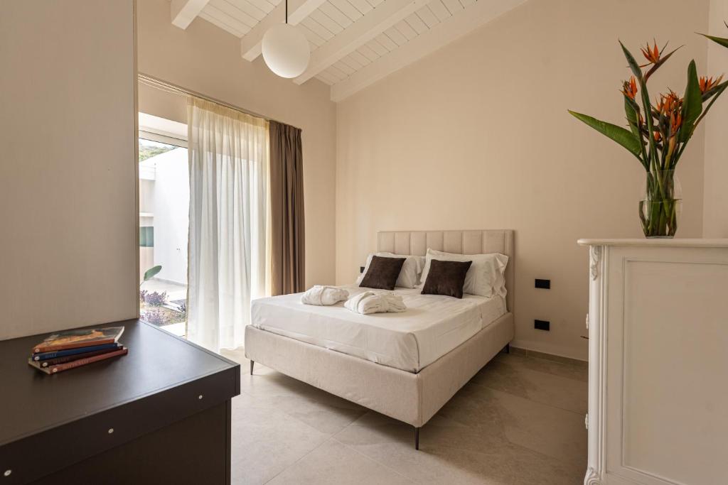 une chambre blanche avec un lit et une fenêtre dans l'établissement Villa Dafni Private Pool & Relax near Cefalù, à Campofelice di Roccella