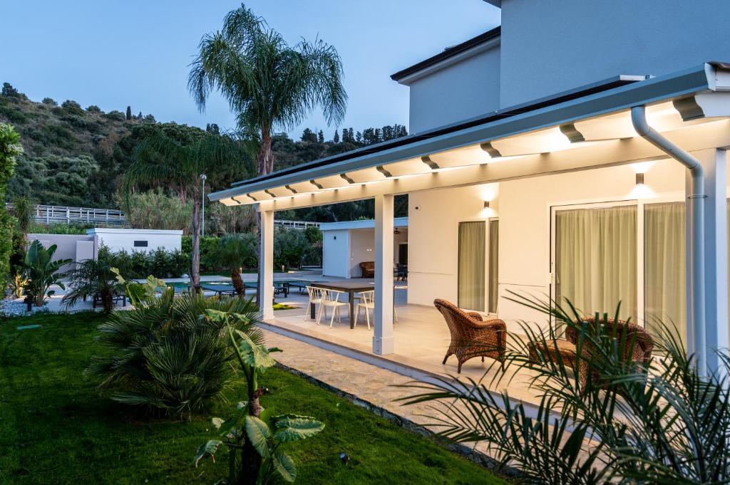 Cette maison dispose d'une terrasse avec une table. dans l'établissement Villa Dafni Private Pool & Relax near Cefalù, à Campofelice di Roccella
