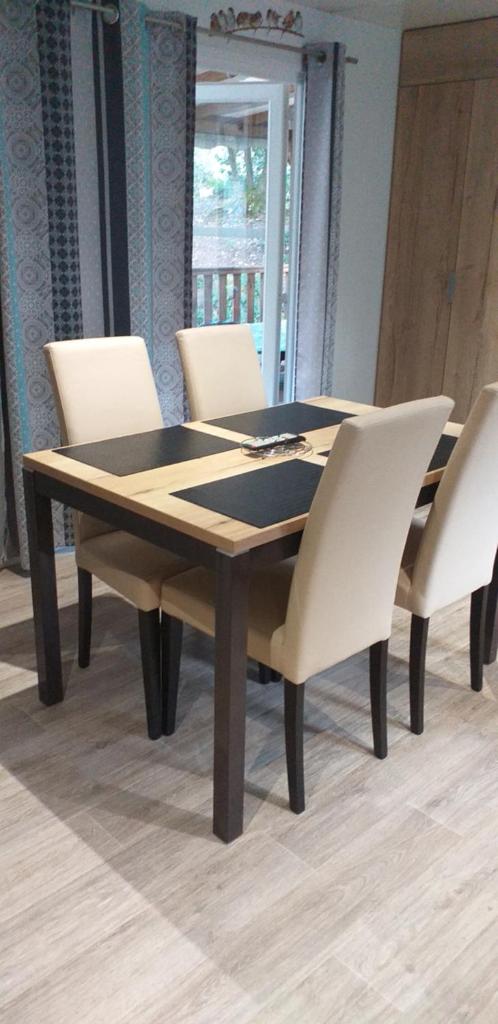 une table de salle à manger avec des chaises blanches autour dans l'établissement Mobilhome Bora Bora 2018 Camping Les Pierres Couchées Saint Brevins les Pins, à Saint-Brévin-les-Pins