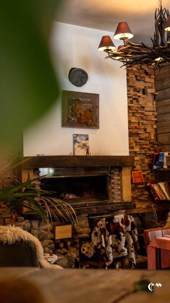 d'un salon avec une cheminée et une horloge murale. dans l'établissement Hotel Green Ecolodge, à La Colmiane