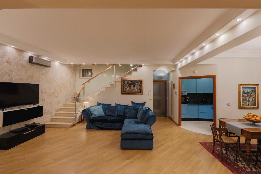 - un salon avec un canapé bleu et un escalier dans l'établissement Musa Maris - Villa panoramica con piscina, à Conversano