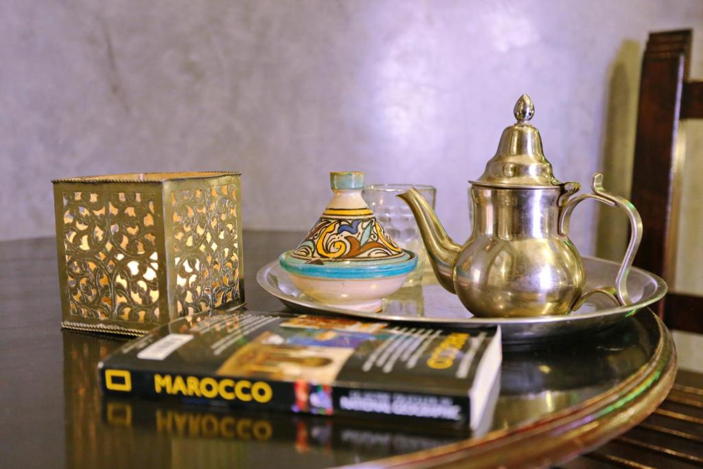 - une table en verre avec un livre et une théière dans l'établissement Riad Marrakiss, à Marrakech 37 autres photos
