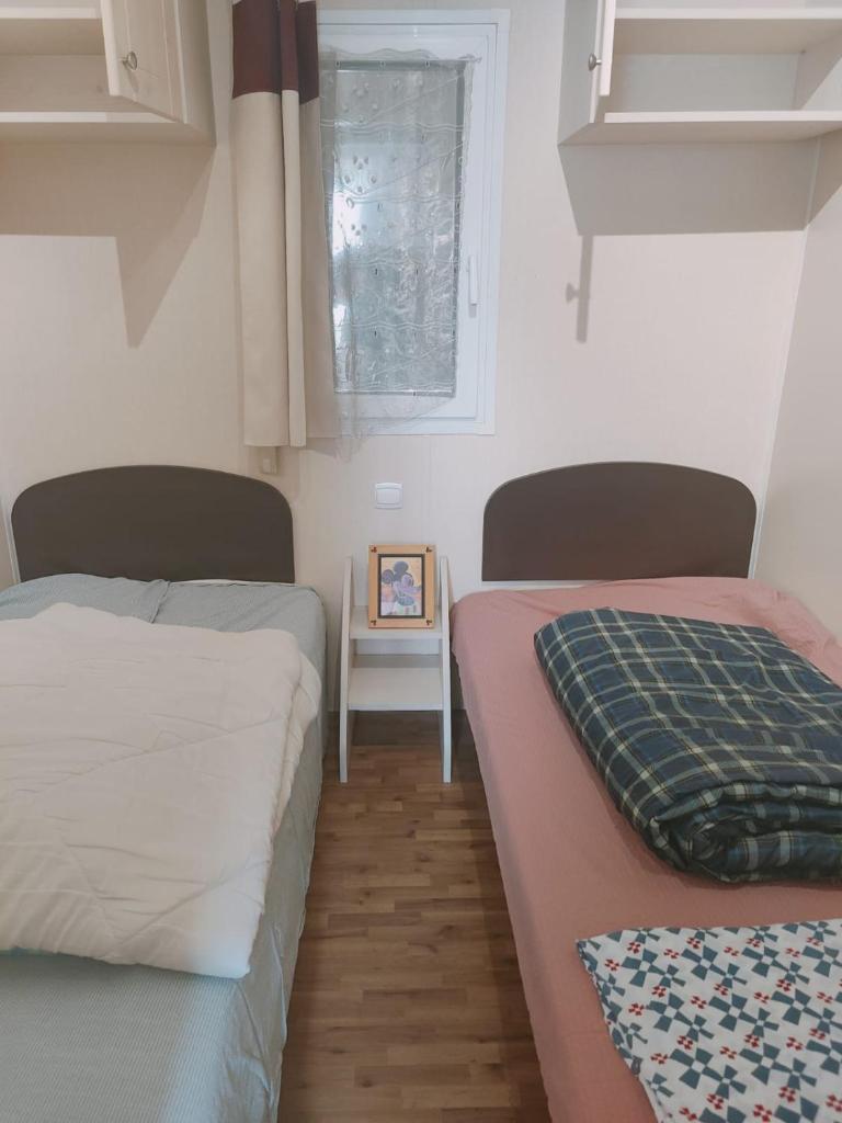 - une chambre avec 2 lits et une photo sur une table dans l'établissement Mobilhome résidentiel, à Gassin