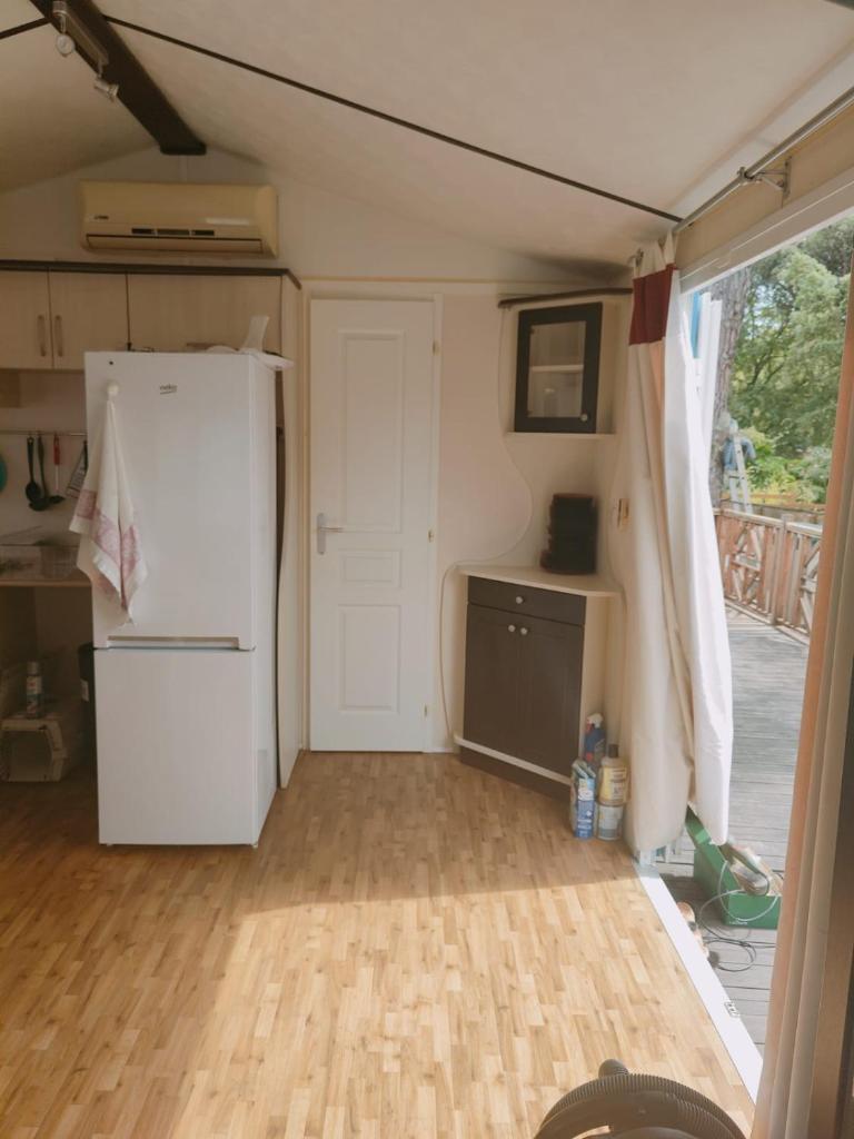 une cuisine avec un réfrigérateur blanc et une porte dans l'établissement Mobilhome résidentiel, à Gassin