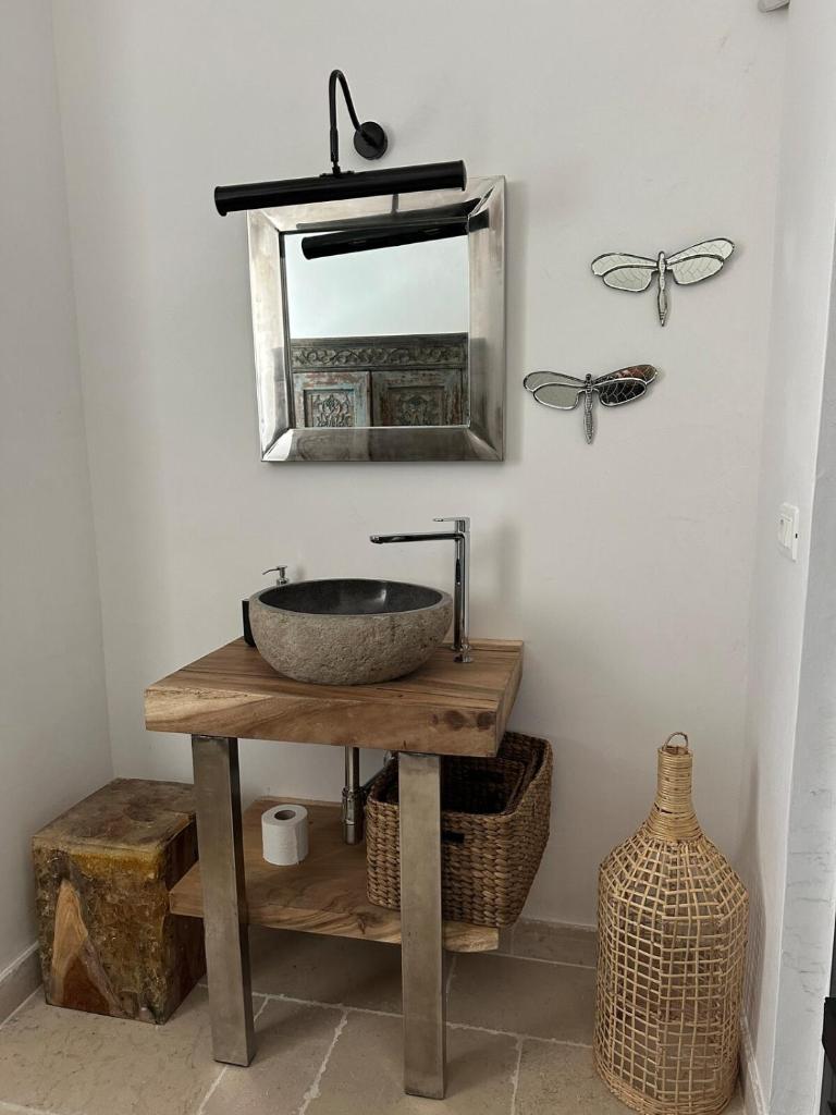 La salle de bains est pourvue d'un lavabo et d'un miroir sur une table. dans l'établissement Villa Batu stylish 2 bedroom, à Cisternino