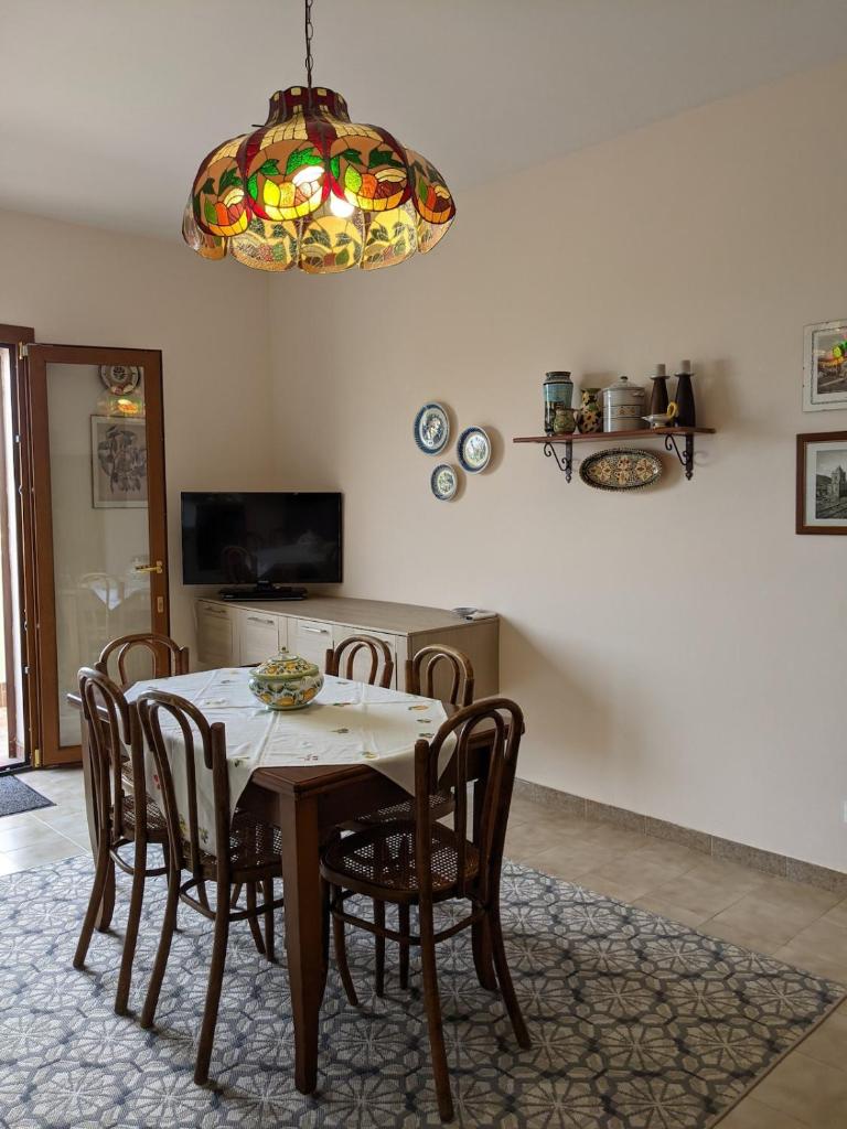 une table à manger avec des chaises et un lustre dans l'établissement Villa with private pool and wonderful view, à Carini