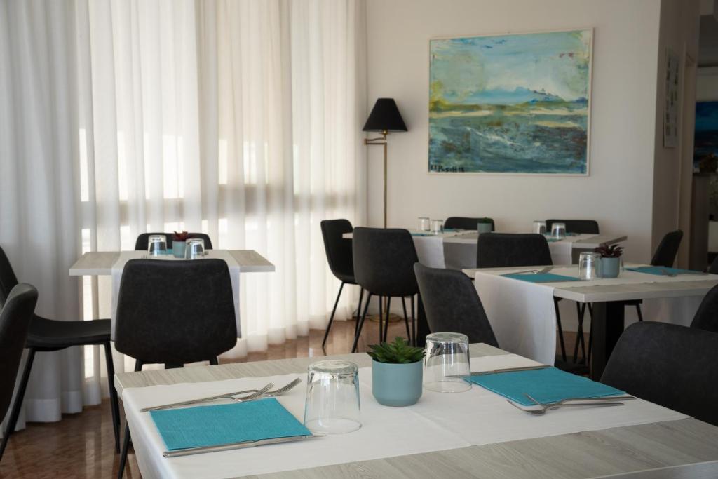 une salle à manger avec des tables et des chaises et un tableau dans l'établissement Hotel Boston 3 Stelle Superior Frontemare, à Lido di Jesolo