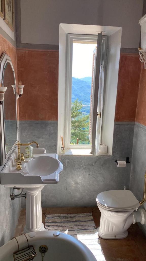 une salle de bain avec un lavabo et des toilettes et une fenêtre dans l'établissement Beautiful Serena, à Coreglia Antelminelli