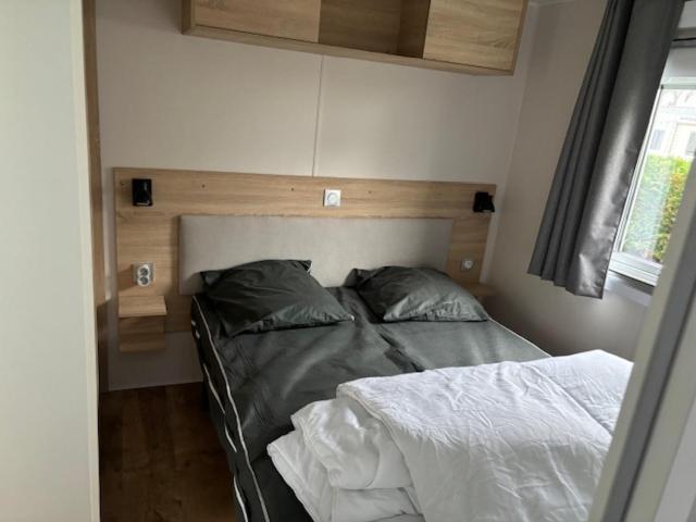 - un lit avec deux oreillers et une tête de lit dans une chambre dans l'établissement Amira 6-8 personnes, à Saint-Jean-de-Monts 1 autre photo