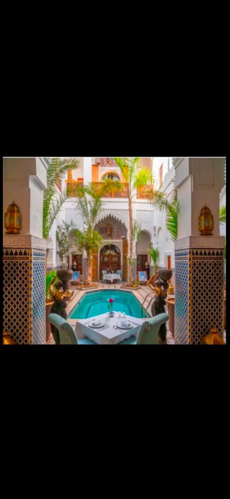 une maison avec une piscine au milieu dans l'établissement Riad & Spa Esprit Du Maroc, à Marrakech