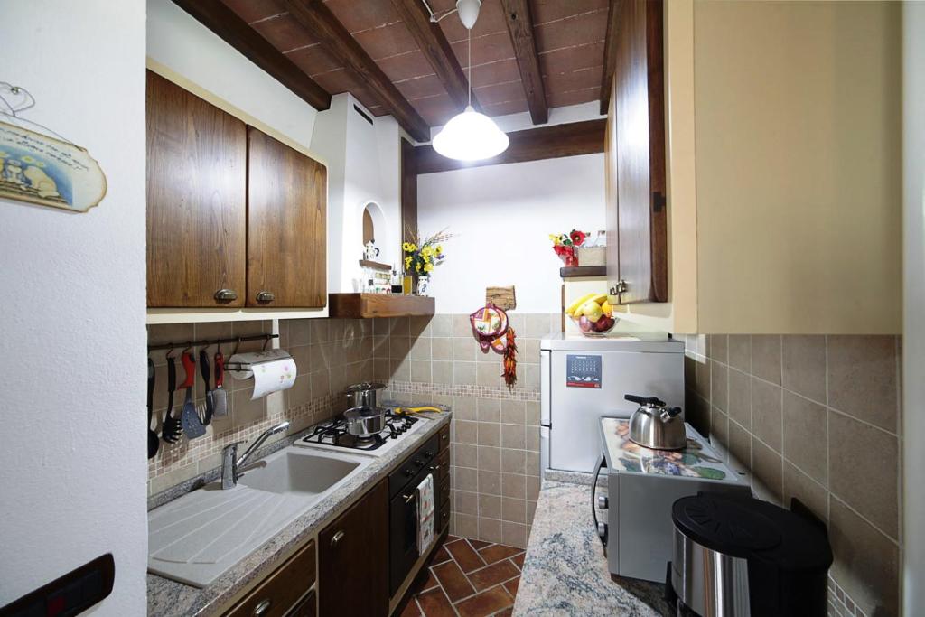 une petite cuisine avec un évier et une cuisinière dans l'établissement La Casetta nel Bosco, à Sinalunga