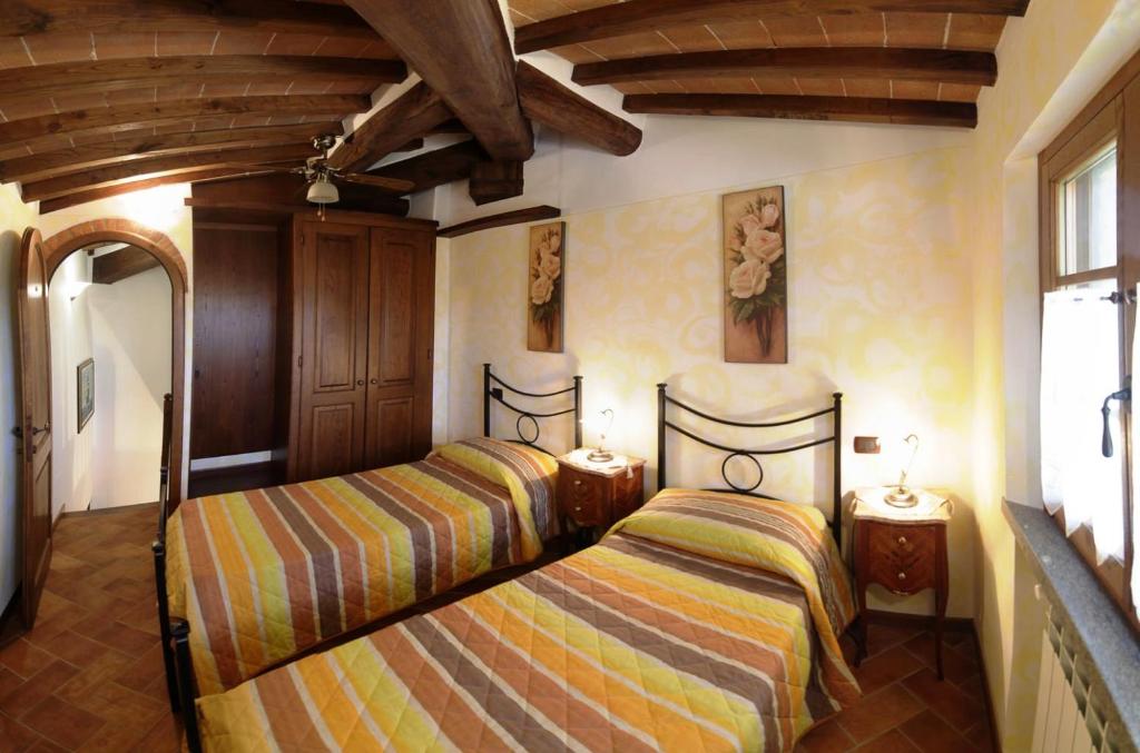 une chambre avec deux lits dans une pièce dans l'établissement La Casetta nel Bosco, à Sinalunga