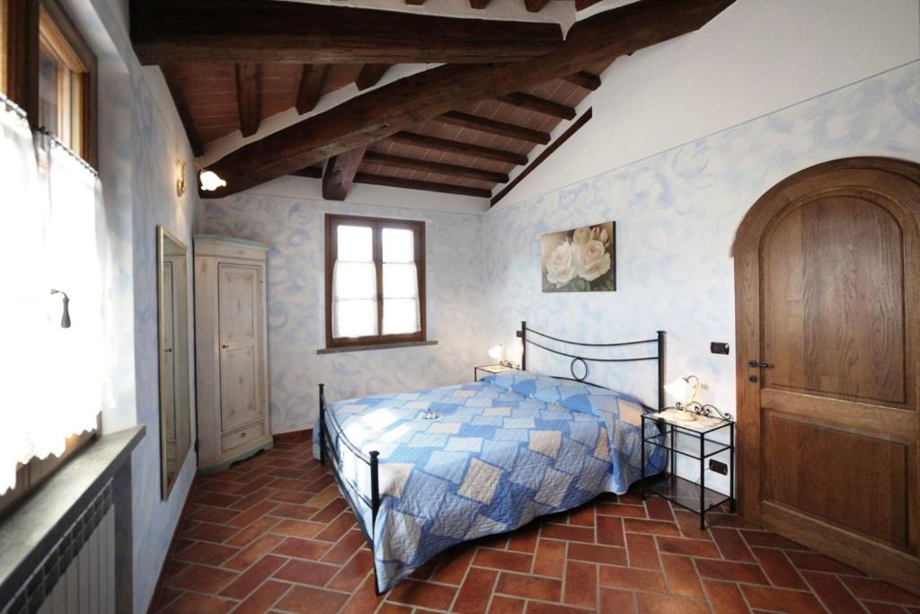 une chambre avec un lit avec une couette bleue dans l'établissement La Casetta nel Bosco, à Sinalunga 15 autres photos