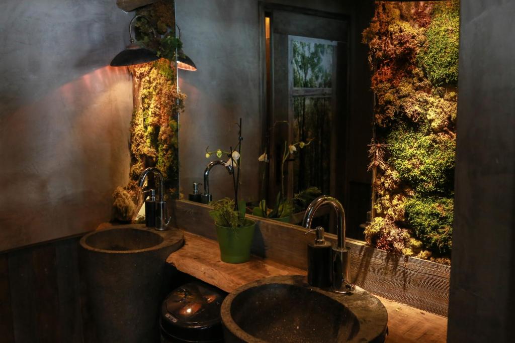 La salle de bains est pourvue de 2 lavabos et d'un coffre à poisson. dans l'établissement Hotel Green Ecolodge, à La Colmiane