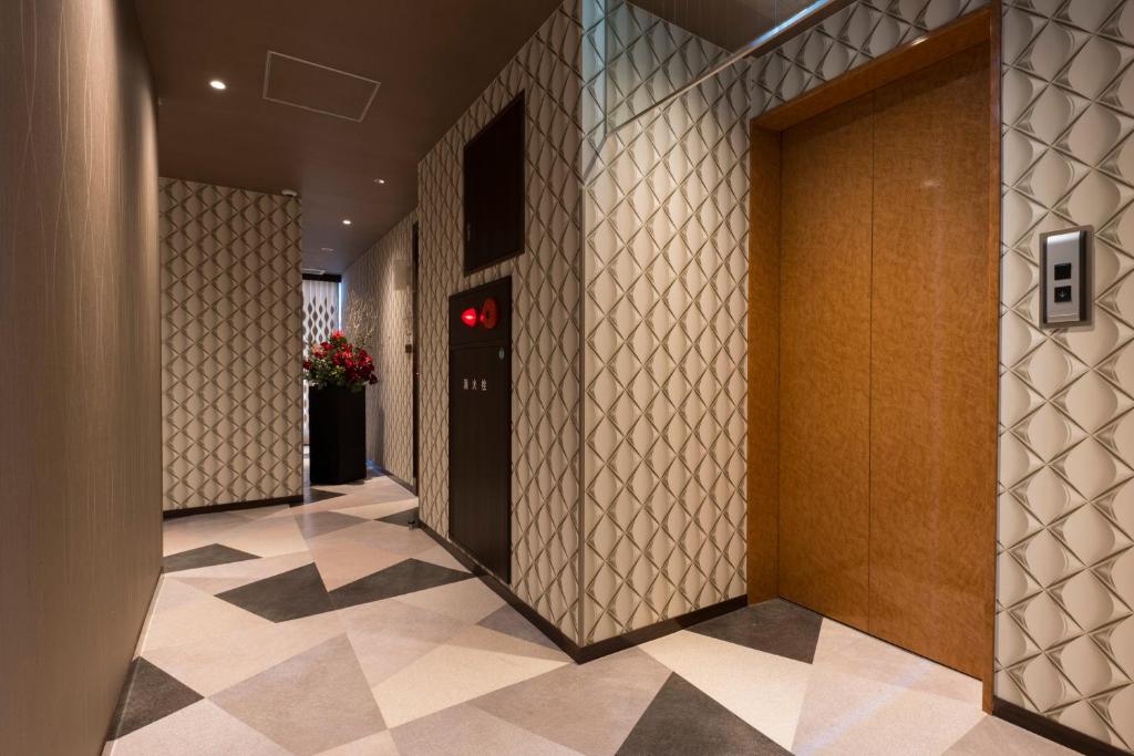 un couloir avec un ascenseur dans un immeuble dans l'établissement Hotel MOZ, à Okayama