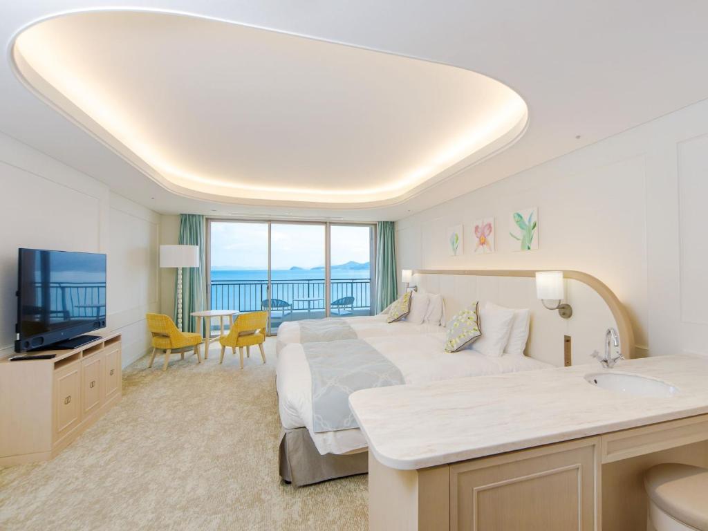 une chambre d'hôtel avec un grand lit et une télévision dans l'établissement Karatsu Seaside Hotel, à Karatsu
