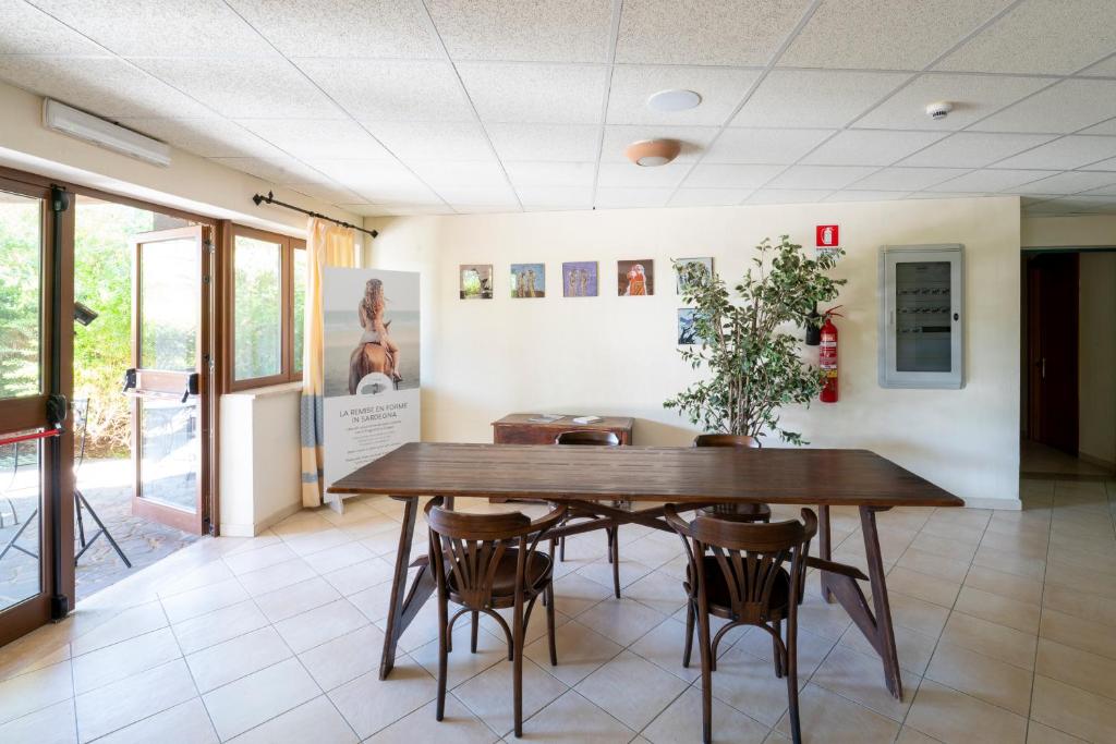 une salle à manger avec une table et des chaises en bois dans l'établissement Horse Country Resort Congress & Spa - Hotel Medar, à Arborea