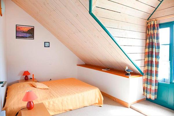 Cette chambre mansardée dispose d'un lit et d'une fenêtre. dans l'établissement Camping Domaine de Kermario, à Carnac