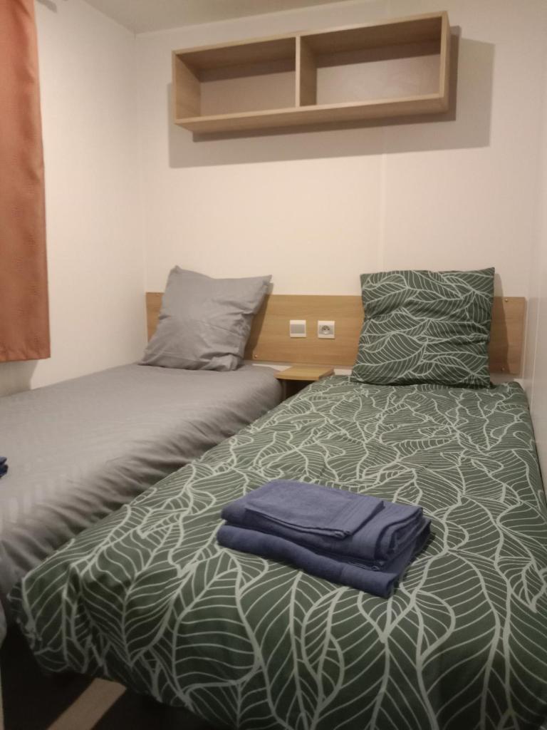 deux lits côte à côte dans une chambre dans l'établissement Siblu Domaine de Kerlann mobile home LUMINOSA, à Pont-Aven 37 autres photos