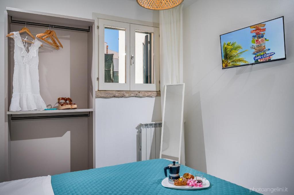 une pièce avec une table avec une assiette de nourriture et une robe dans une fenêtre dans l'établissement VILLA AGLEA Luxury By Sicily Home Solutions, à Castellammare del Golfo