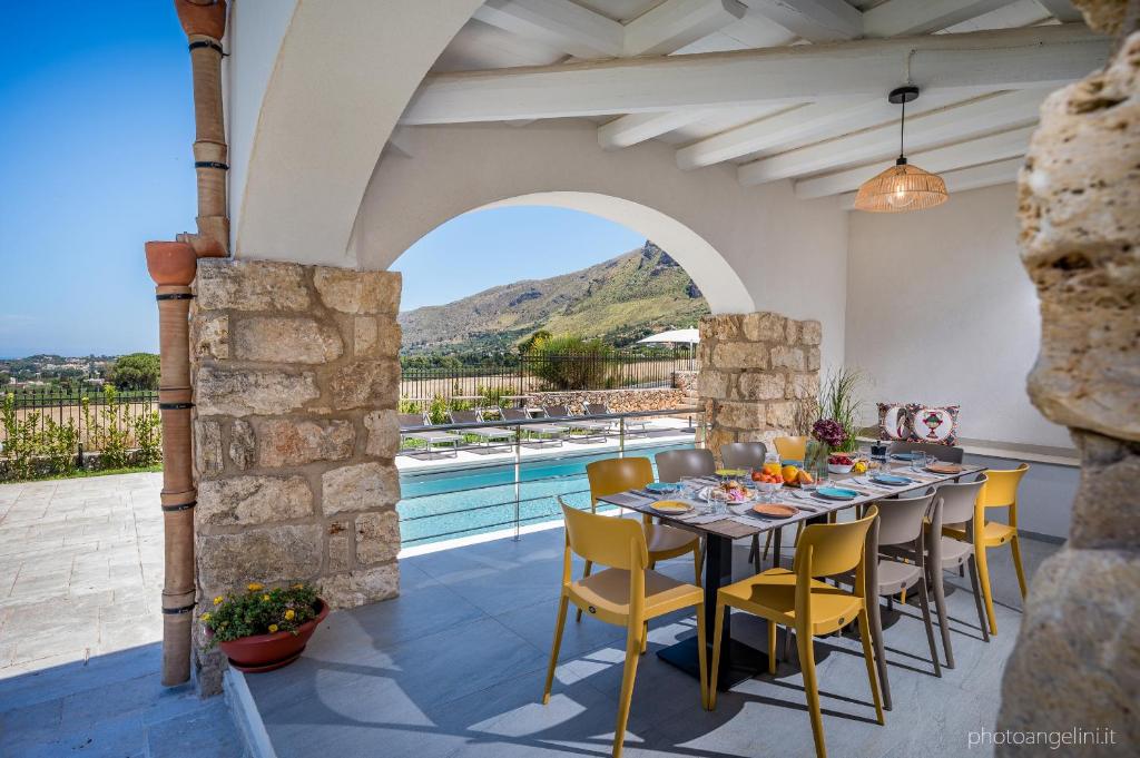 une salle à manger avec une table et des chaises jaunes dans l'établissement VILLA AGLEA Luxury By Sicily Home Solutions, à Castellammare del Golfo