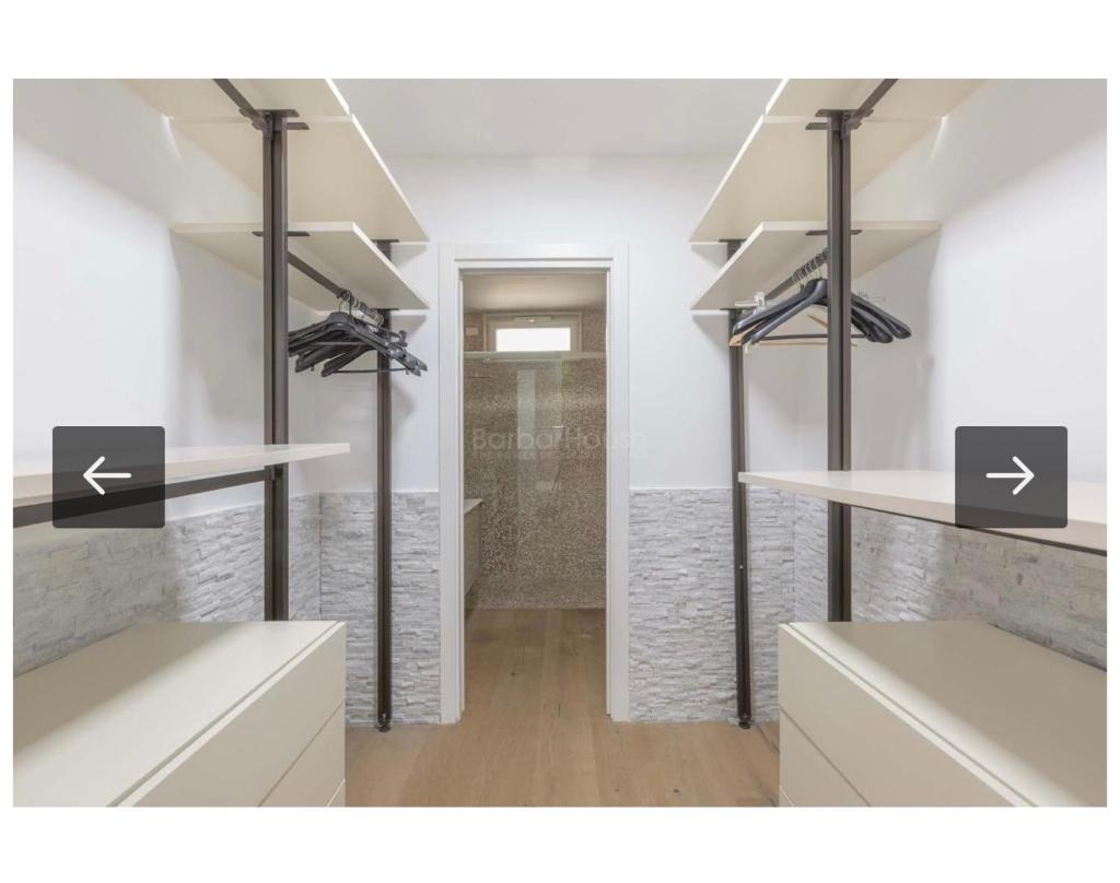 Cette chambre dispose d'étagères blanches et d'un couloir. dans l'établissement Villa Ilaria, à Capitolo